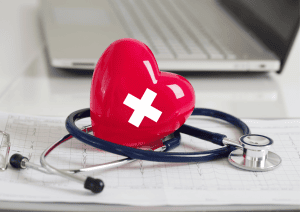 coeur avec symbole suisse entouré d'un stéthoscope avec un pc en arrière plan