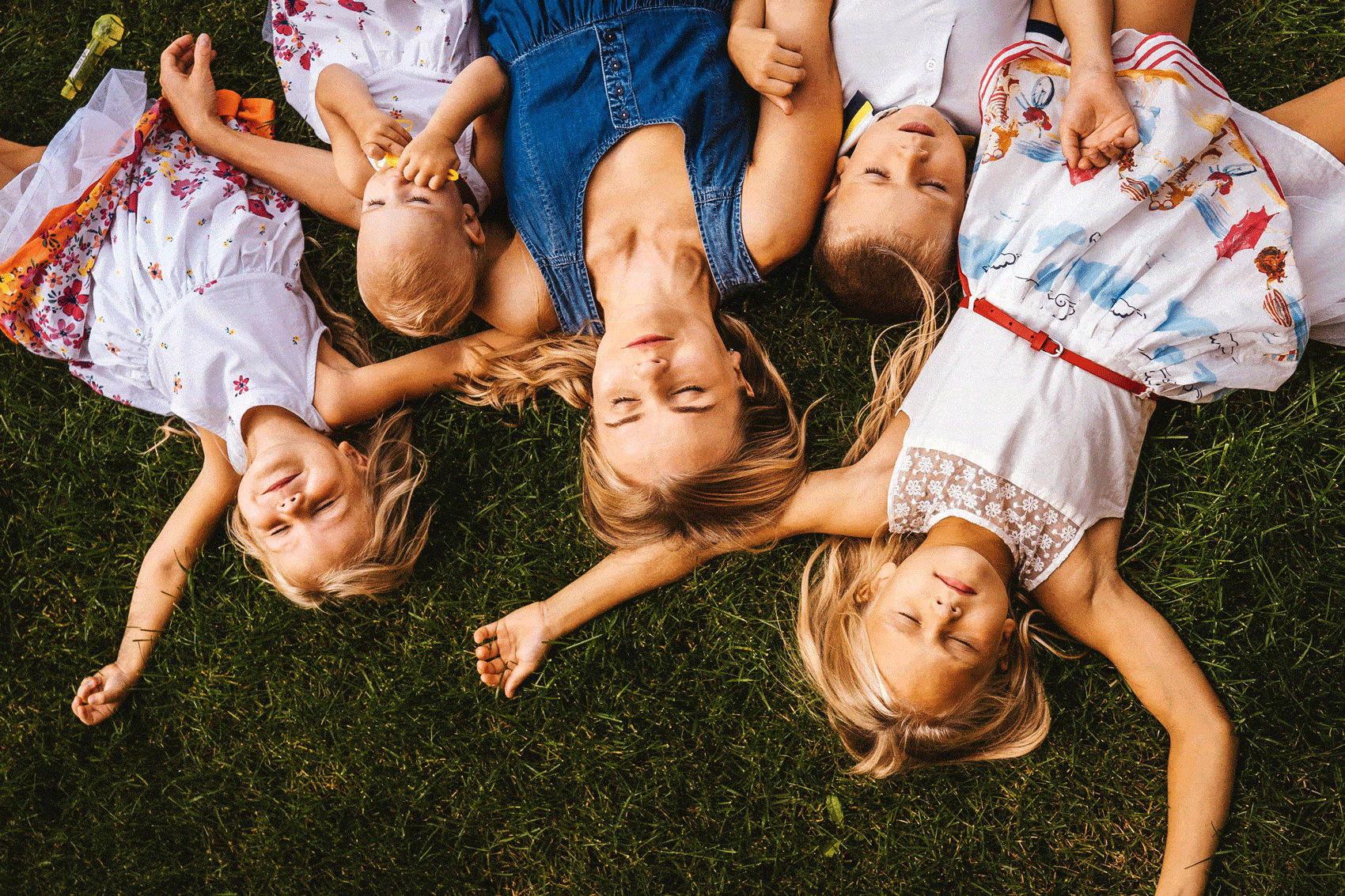 Mère et 4 enfants allongés sur l'herbe