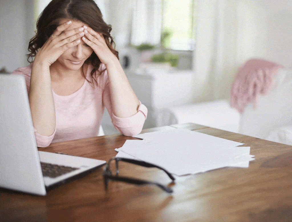 Femme brune avec mains sur la tête à cause de ses factures maladie