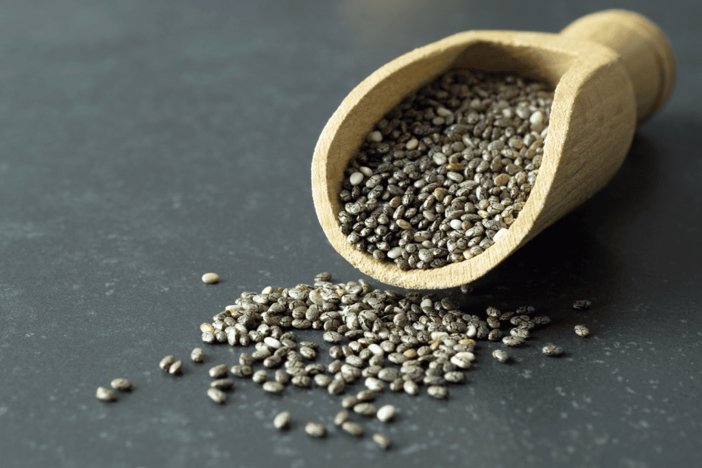 Graines de chia sortant d'une cuillère en bois