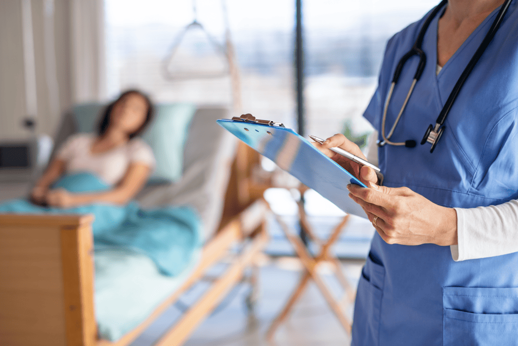 Médecin dans une chambre d'hôpital, une patiente couchée en arrière plan