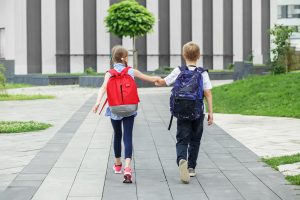 Fillette et garçon entrain de marcher avec sac à dos