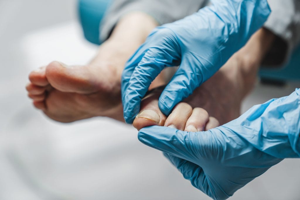 main d'un podologue qui analyse un pied