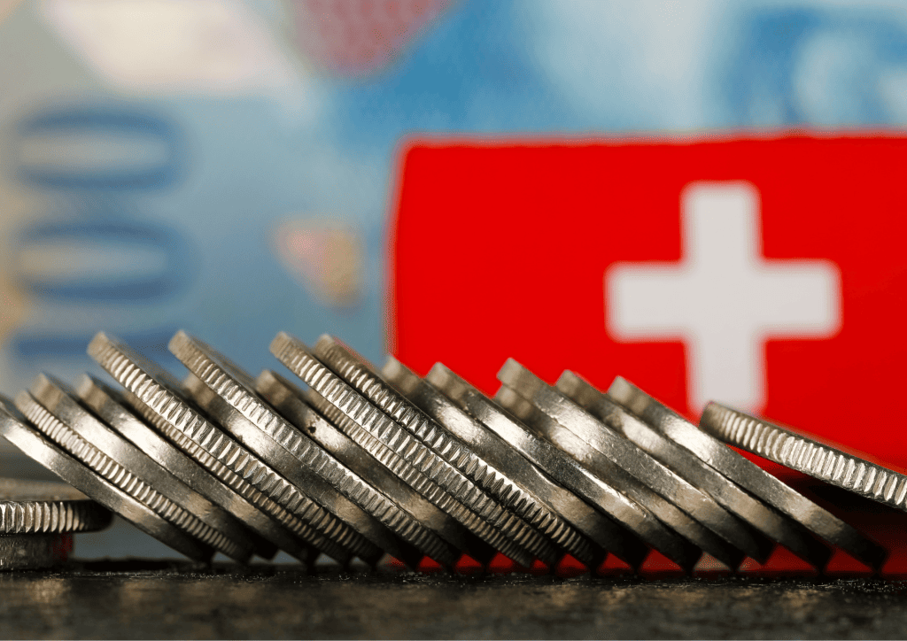 pièces de monnaie suisses avec drapeau suisse en arrière plan