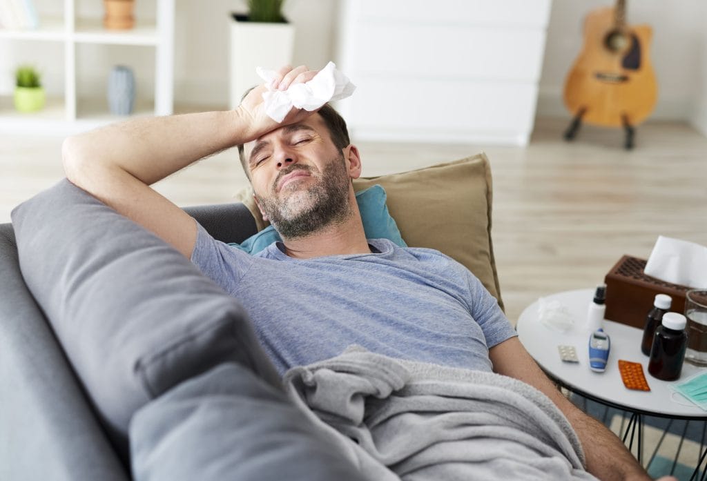 Homme malade couché sur un canapé.