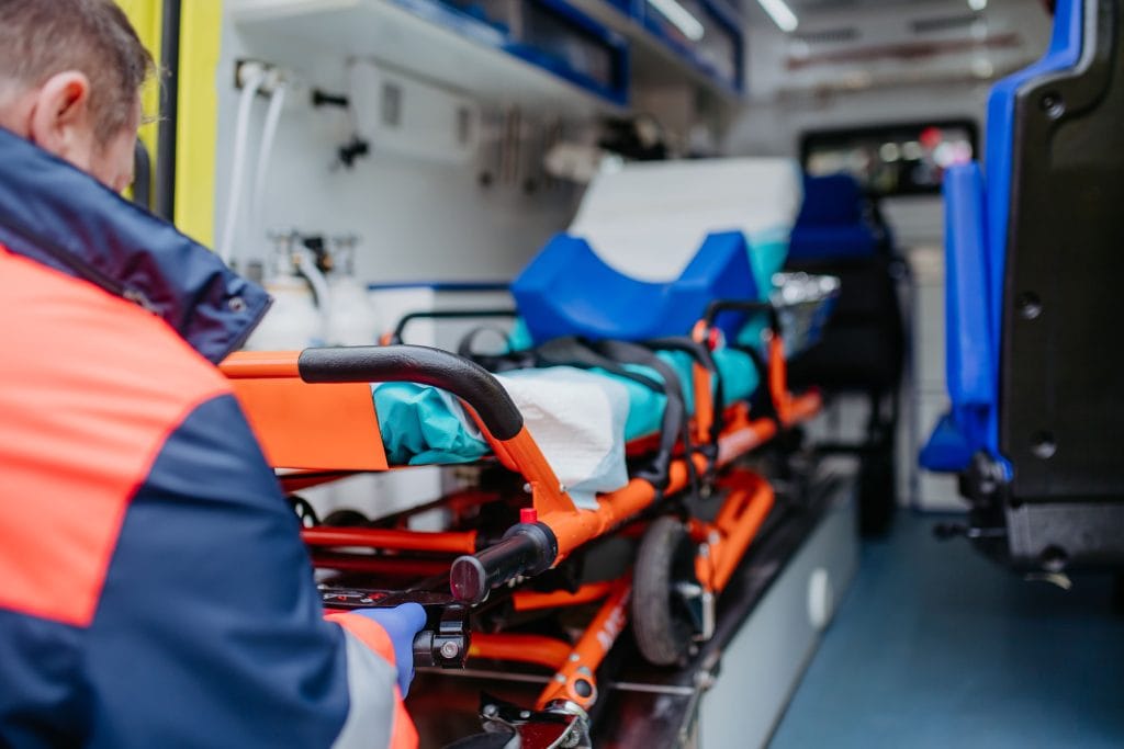 Ambulancier qui met brancard dans une ambulance