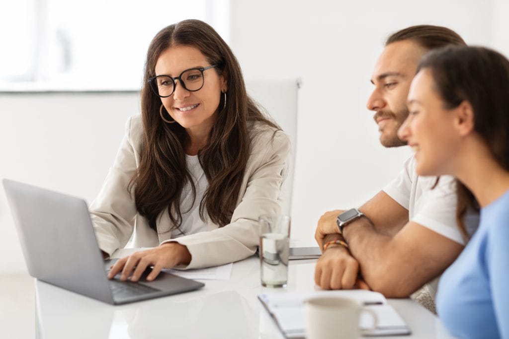 Femme conseillère en assurance conseillant un couple de client.