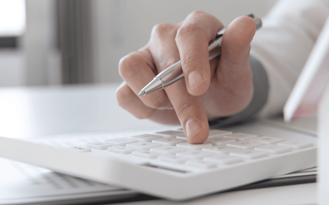 Personne utilisant une calculatrice pour calculer le coût de ses assurances complémentaires.